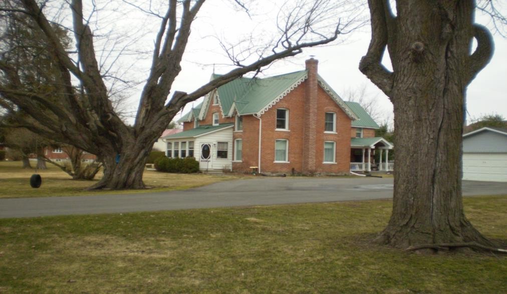 A red-brick house behind a large tree at 74 Craig Street.