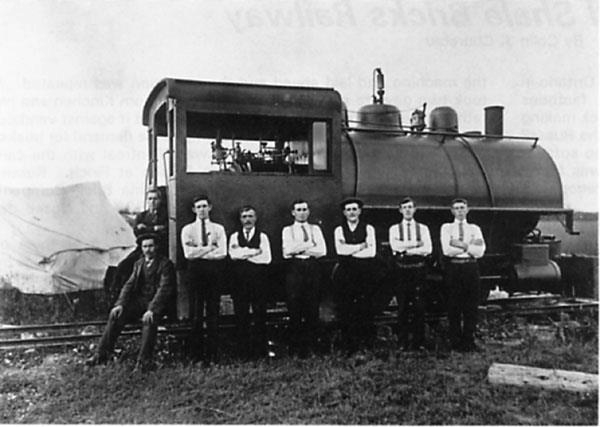 Workers standing beside the narrow-gauge steam locomotive used at the Russell quarry.