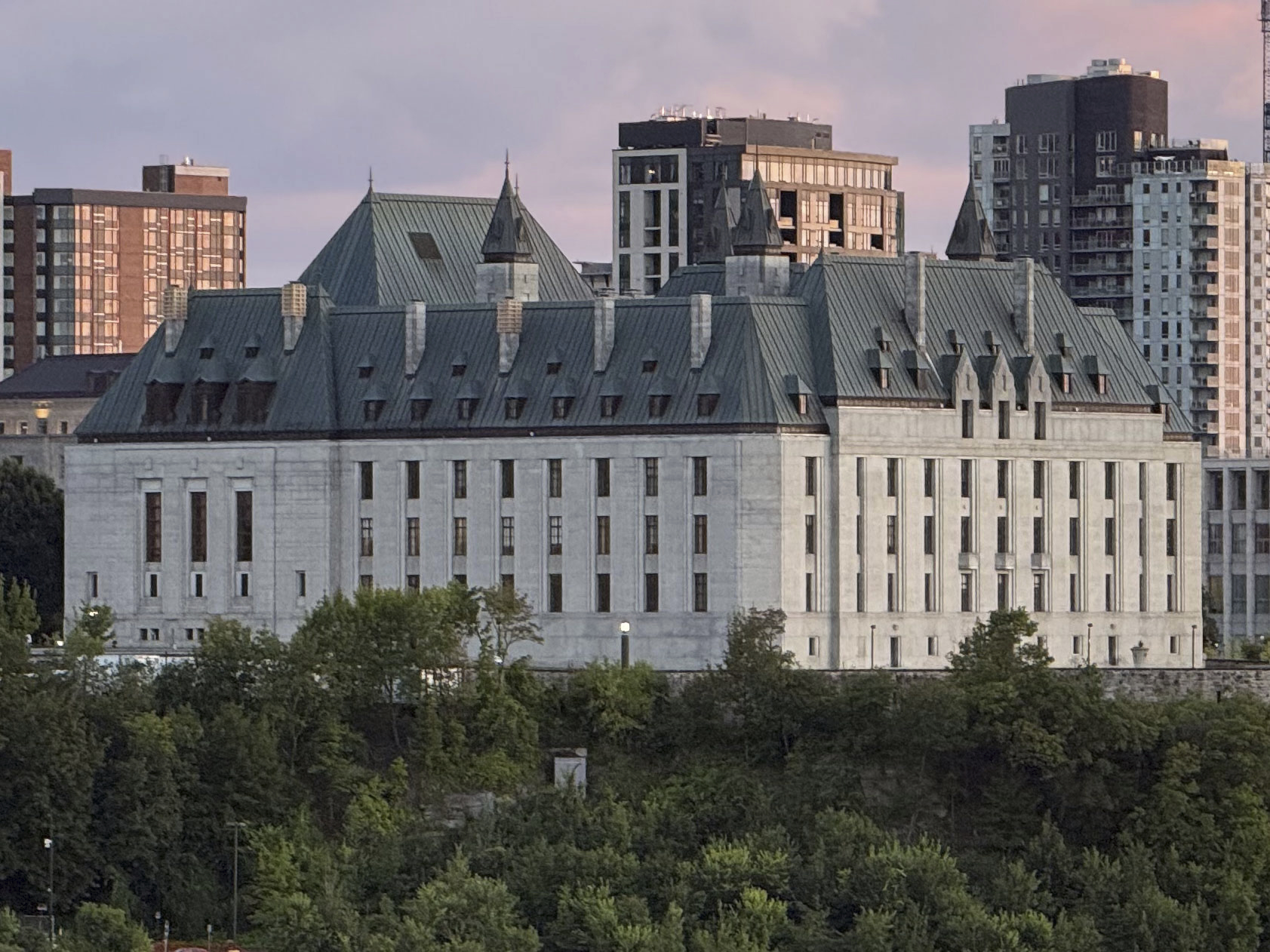 The Supreme Court of Canada building in Ottawa above green trees.